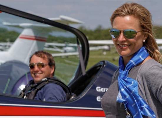 Gerald Cooper aerobatic pilot in Extra, Sarah standing beside, both wearing Bigatmo pilot sunglasses.