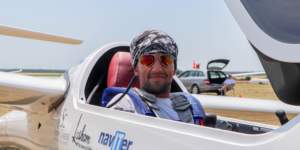 Jake Brattle wearing Bigatmo sunglasses and sitting in his glider before racing in France.